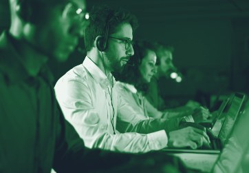 Support engineers with headsets at their desks